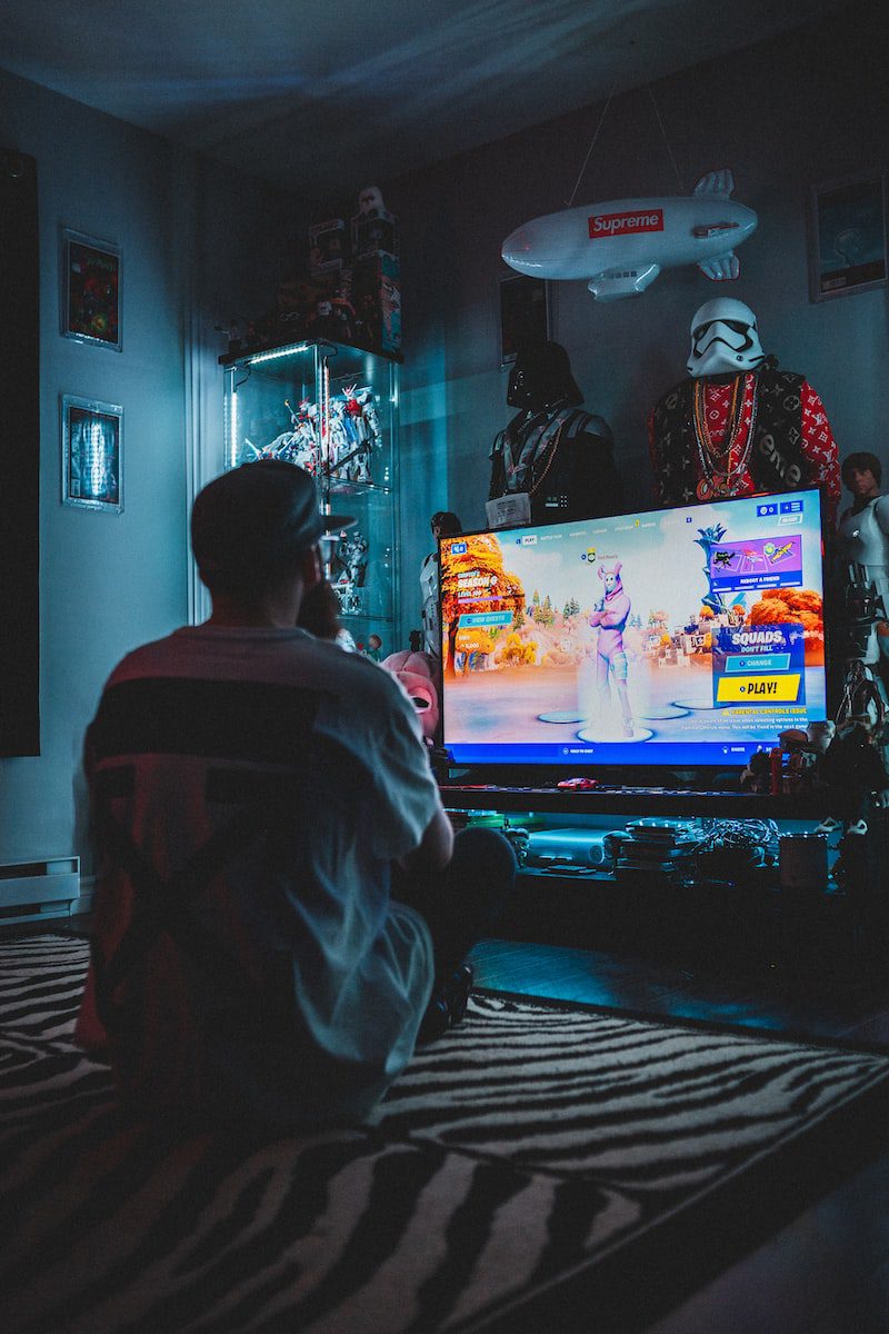 Photo by Erik Mclean man in red shirt watching tv